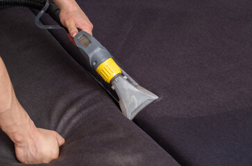 Professional dry cleaning of the sofa with a special chemical solution and a washing vacuum cleaner. Copy space for text