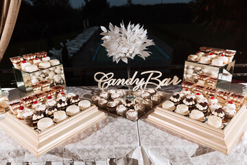 Festive dessert table with sweets. Wedding candy bar, various cakes, chocolates on stands.