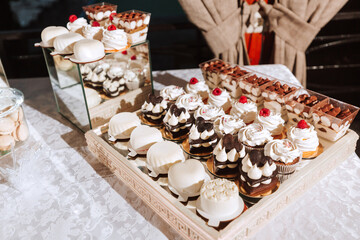 Festive dessert table with sweets. Wedding candy bar, various cakes, chocolates on stands.