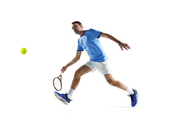 Obraz na płótnie Canvas Active, sportive man in uniform playing tennis, hitting ball with racket during game isolated over white background. Concept of sport, active lifestyle, game, hobby, health, dynamics, ad