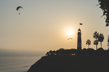 Paragliding during the Sunset in la Costa Verde (Green Coast) near Marine Lighthouse in Lima, Peru