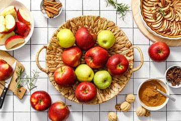 Apple. Fresh raw juicy red and green apples in a basket on a kitchen table with ingredients for cooking Thanksgiving autumn season apple pie, top view