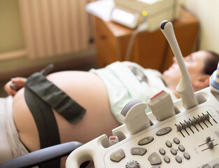Pregnant girl on ultrasound examination during pregnancy. Study of the size of the fetus,...