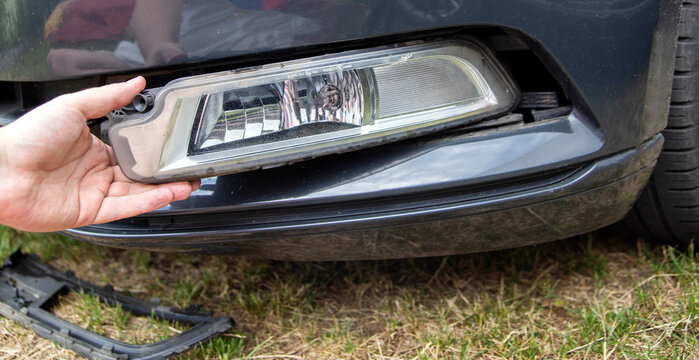Disassembling and removing the fog lamp from a car to replace a burnt out light bulb. Close-up
