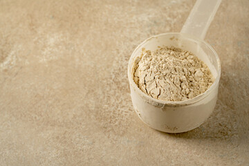 Protein powder in a scoop with two glasses of protein drink. Bodybuilding, fitness sport, health and nutrition.