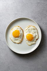 Fried eggs in a plate, food breakfast, healthy proteins. 