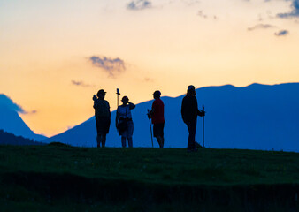 Obraz premium Silueta de 4 personas en la montaña en el atardecer
