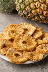 Plate with dried sweet pineapple slices close up  