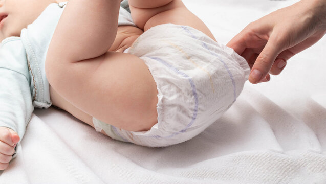 Mother checks baby's diaper clean or dirty. Close-up