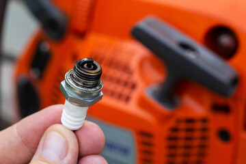 Carbon deposits on a spark plug in a chainsaw. Re-enriched fuel mixture. Malfunction in the...