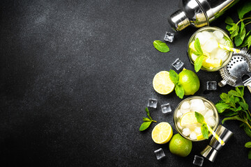 Mojito with rum, lime, mint and ice on black background with bar utensils. Flat lay with copy space. - obrazy, fototapety, plakaty