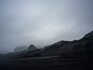 Mýrdalsjökull Glacier covered in sand and dark soil. By the entrance of Katla Ice Cave. South Iceland.