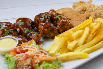 Chicken mix, wings in bbq sauce, nuggets and chicken pieces, accompanied by French fries, salad and mayonnaise