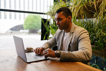 Man working on laptop at cafeteria