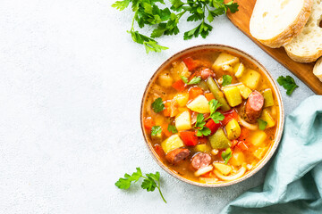 Minestrone soup, italian vegetable soup with smoked sausages, Top view with copy space.