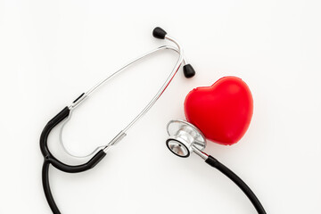 Cardiology and insurance concept with red heart and medical stethoscope