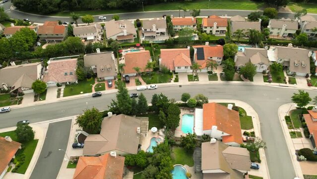 Aerial view of beautifull houses in Los Angeles. Wealthy district of villas with swimmign pools and trees near the road. Cars drive the boulevard. Los Angeles California USA. High quality 4k footage