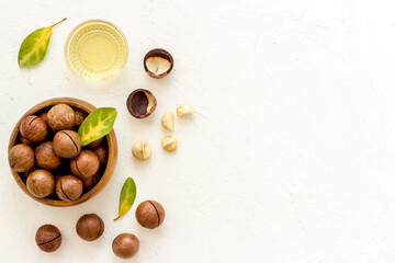 Macadamia nuts oil with raw shelled nuts, top view