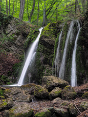 Fototapeta na wymiar waterfall at the spring misty forest