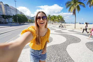 Tuinposter Fashion tourist woman takes selfie photo on Copacabana beach promenade, Rio de Janeiro, Brazil © zigres