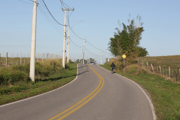Fototapeta na wymiar Linda estrada asfaltada com placa de sinalização para ciclista no local.