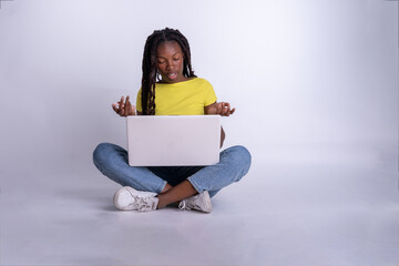 Mujer hermosa joven de color  que usa un ordenador portátil con un fondo blanco. Chica blogger...
