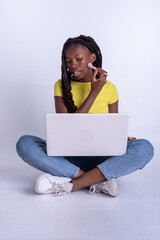Mujer hermosa joven de color  que usa un ordenador portátil con un fondo blanco. Chica blogger...