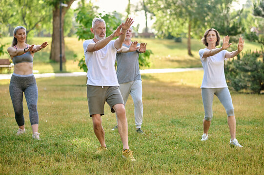 A group of people practicing qigong in a park