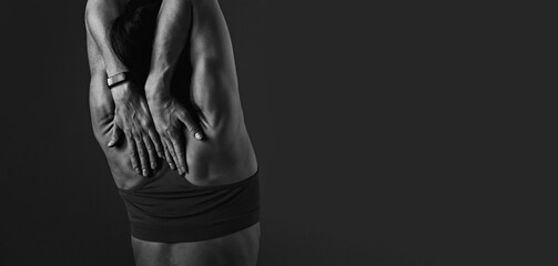Female sporty muscular stretching and massage workout of the shoulders, blades holding the hands on the shoulders and blades on dark grey background with empty copy space. Back view. - 617856832