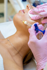PRP ttherapy in beauty clinic, cosmetologist doing injections to woman's face to cure problem skin.