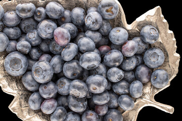 Several ripe blueberries with metal tray on black background, macro, top view.