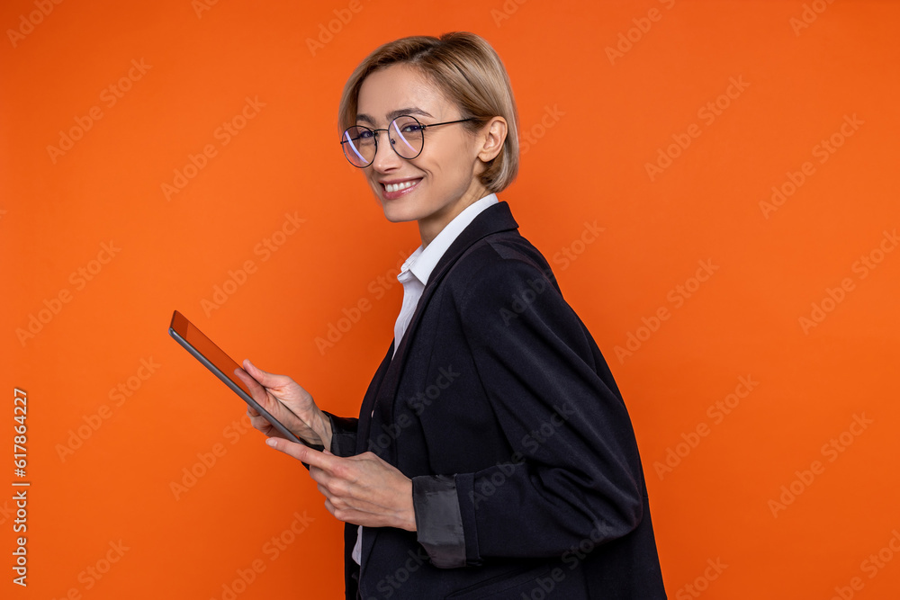 Wall mural Profile portrait of happy woman wearing black official style suit working online on tablet