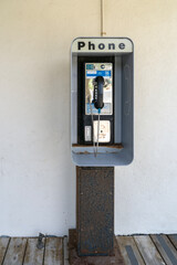 Vintage, old school payphone mounted on metal stand.