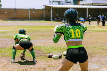 women practice American football on a sunny afternoo
