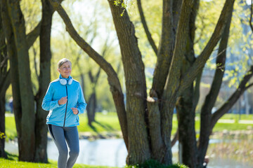 Woman in blue blazer running in th morning park