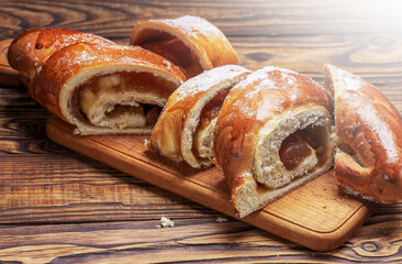 cut sweet bun with jam on a wooden board