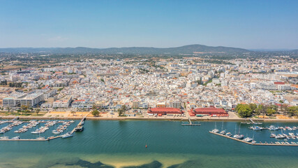 Naklejka premium Aerial view of Portuguese fishing tourist town of Olhao with a view the Ria Formosa Marine Park. Sea port for yachts frontal view.
