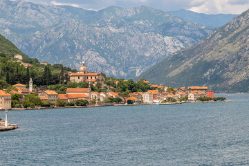 Landscape Exposure done from a cruise ship, showing the sea entrance to Kotor bay and its beautiful coastal landscapes and small villages , on a sunshiny day.