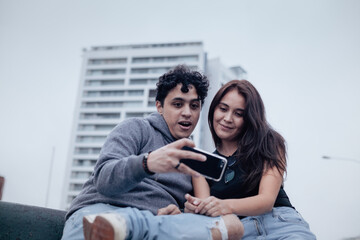 Obraz premium Photograph of a young couple looking attentively at a cell phone. Lifestyle concept, convenience and couples.