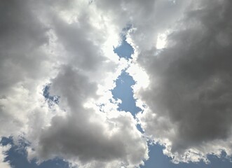 Huge clouds being illuminated by sunlight at noon