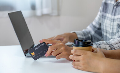 Young couple consumer hand holding mock up credit card, Ready to spend pay online shopping according to discount products via smartphone and laptop from home office
