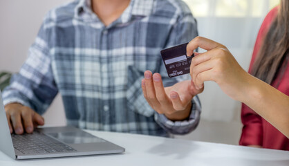 Young couple consumer hand holding mock up credit card, Ready to spend pay online shopping according to discount products via smartphone and laptop from home office