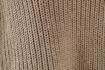 Knit fabric texture. Detail of a beige sweater.  