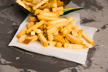 Fragrant salty crackers from rye bread on a gray concrete background. A tasty snack for beer.