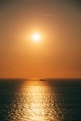 Puesta de sol con barco y mar de fondo