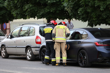 Akcja straży pożarnej podczas wypadku samochodowego. Ratowanie rannego kierowcy. - obrazy, fototapety, plakaty