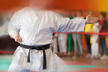 A martial artist in a white kimano with a black master belt demonstrates a technique. Added motion...
