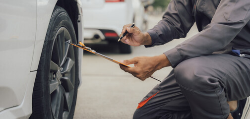 car service, repair, maintenance concept - Asian auto mechanic man or Smith writing to the...