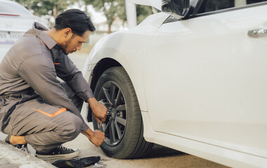 Fototapeta premium car service, repair, maintenance concept - Asian auto mechanic man or Smith writing to the clipboard at workshop warehouse, technician doing the checklist for repair machine a car in the garage,banner