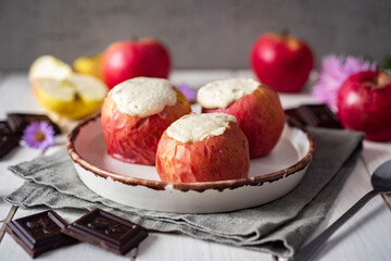 Sweet dessert: Baked apples with cottage cheese on a beautiful white plate for breakfast. Close-up